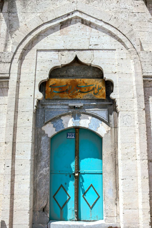 two old blue doors in a building on a sunny day