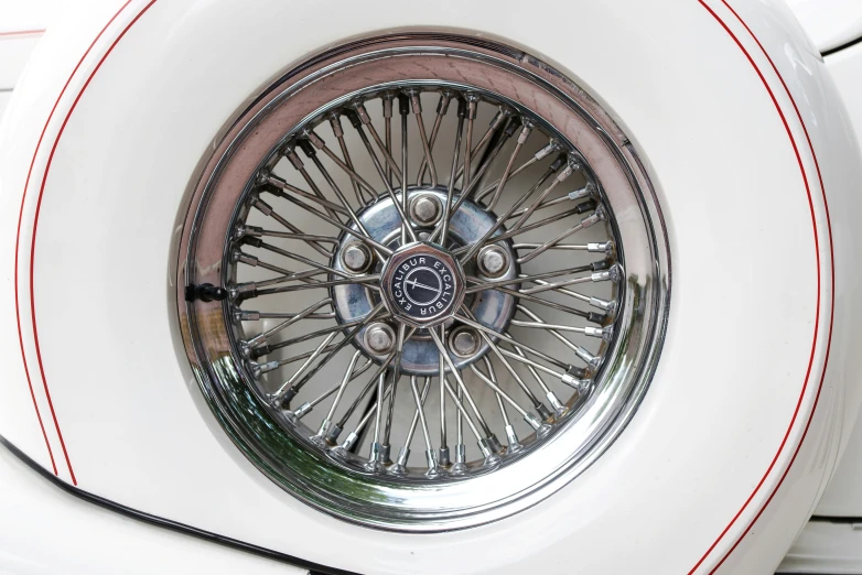 the wheel of a white sports car with red stripes