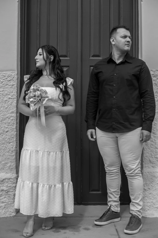 a man and woman standing in front of a doorway