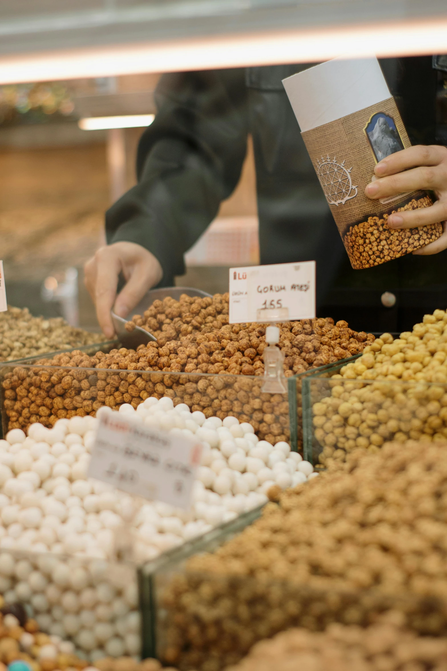 a vendor is selecting beans at the market