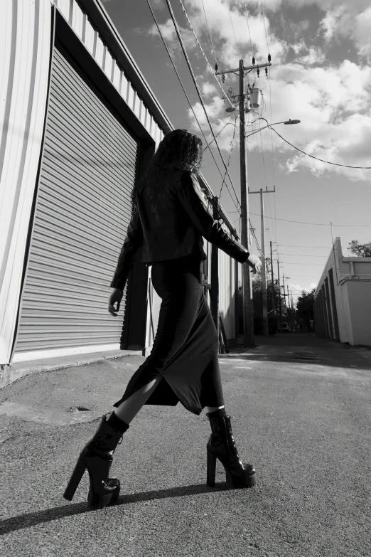 a woman walking across a street wearing boots