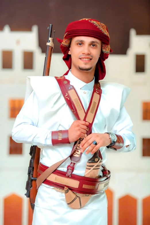 a man is holding a rifle and wearing red head coverings