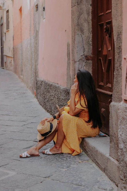 a woman with long hair sitting outside a building