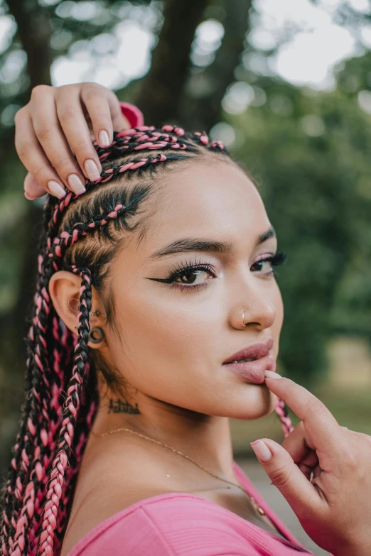 an asian woman with pink hair is putting on her makeup