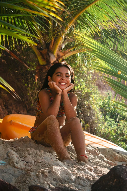  sitting on sandy beach next to palm tree