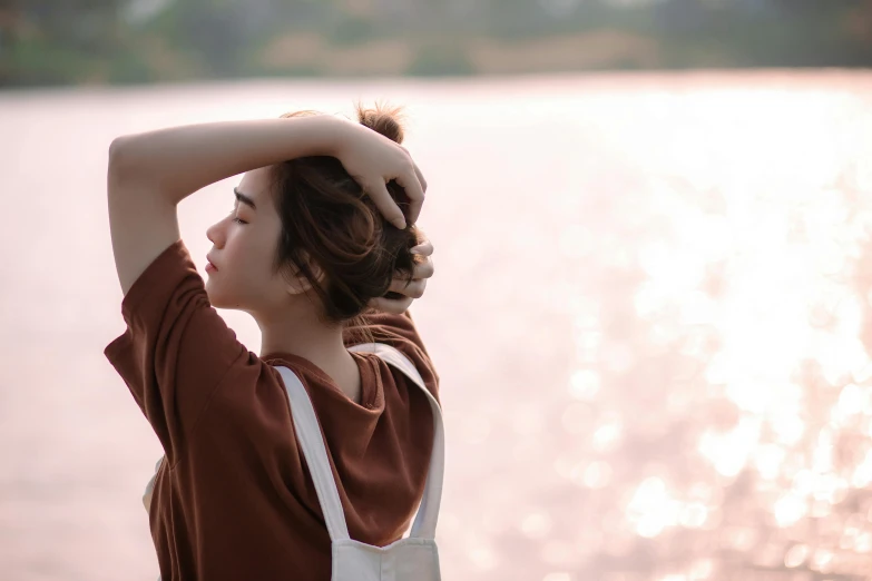 woman standing near water wearing brown shirt and white apron