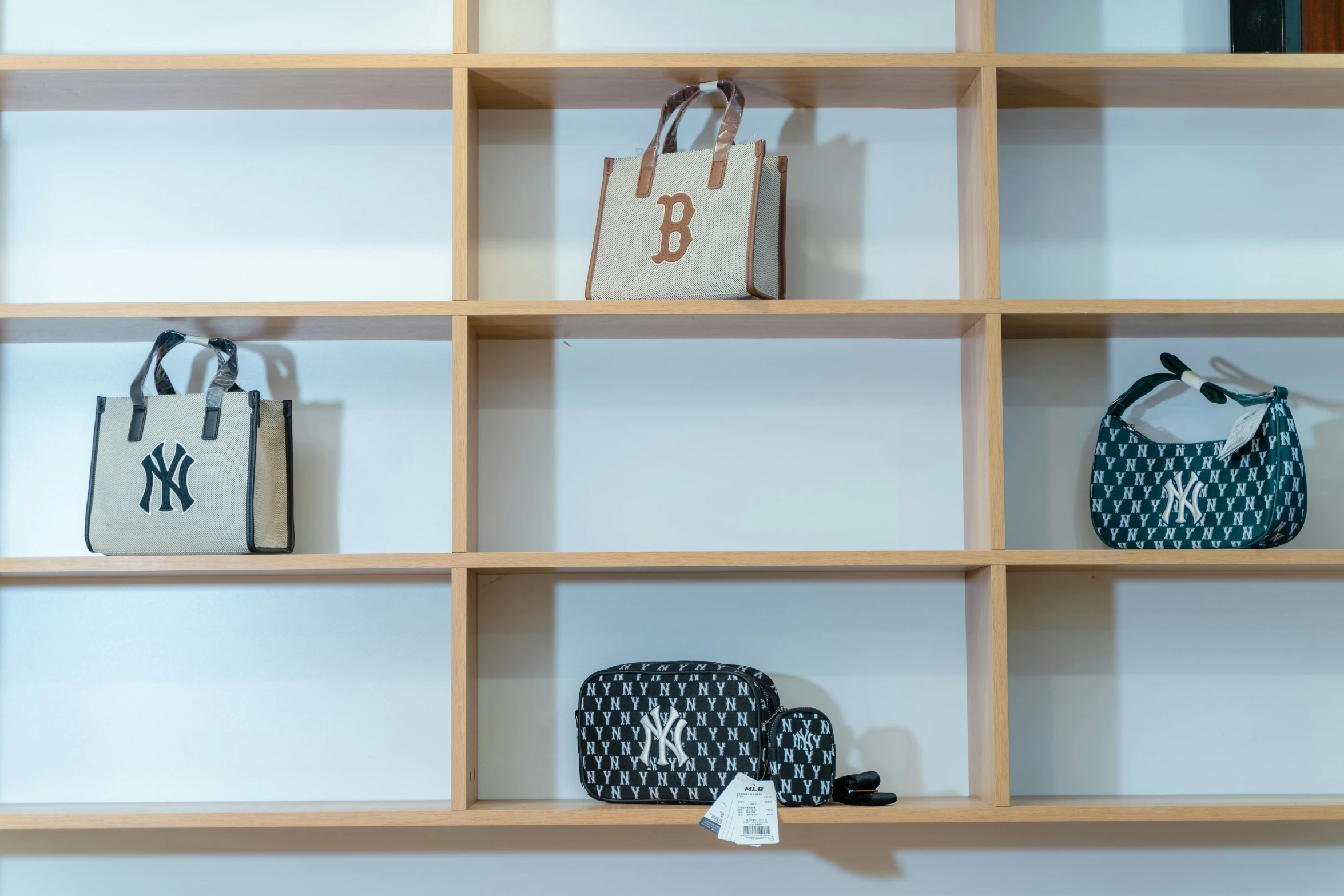 purses are lined up in shelves on white surface