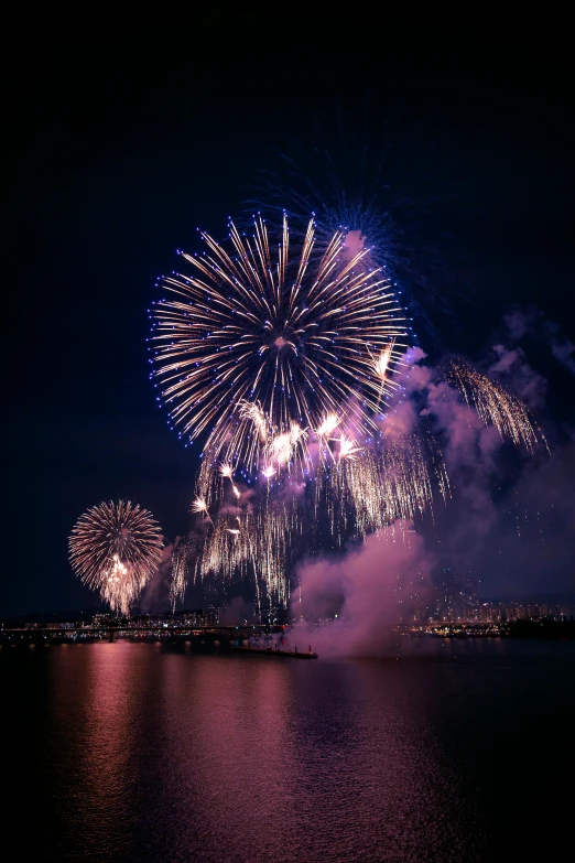 fireworks are lit up in the sky above the water