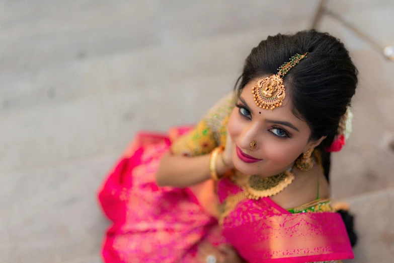 an indian woman poses for a picture while wearing jewelry