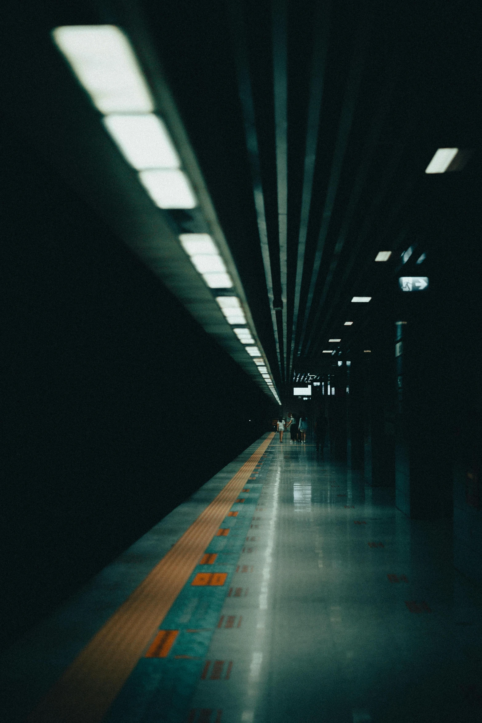 a dark image of a train traveling past a station