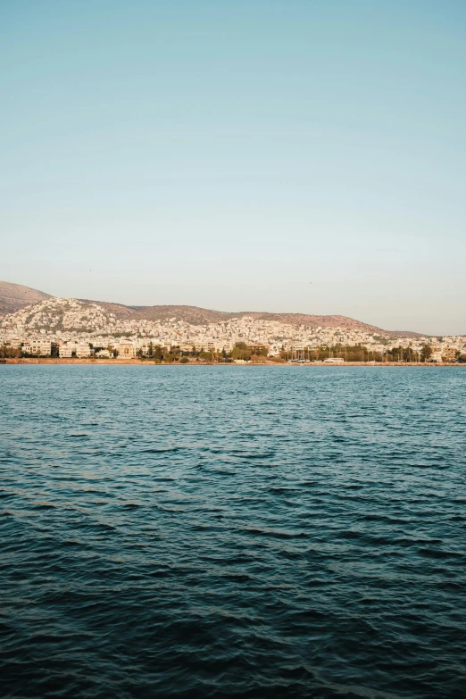 there is a boat on the water near a hill