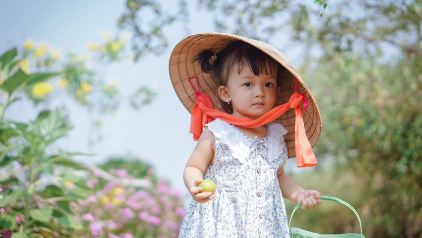 a young child is standing in a field wearing a hat