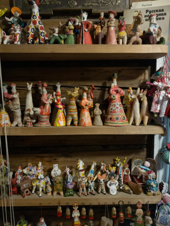 a display shelf with many hand painted vases and dolls