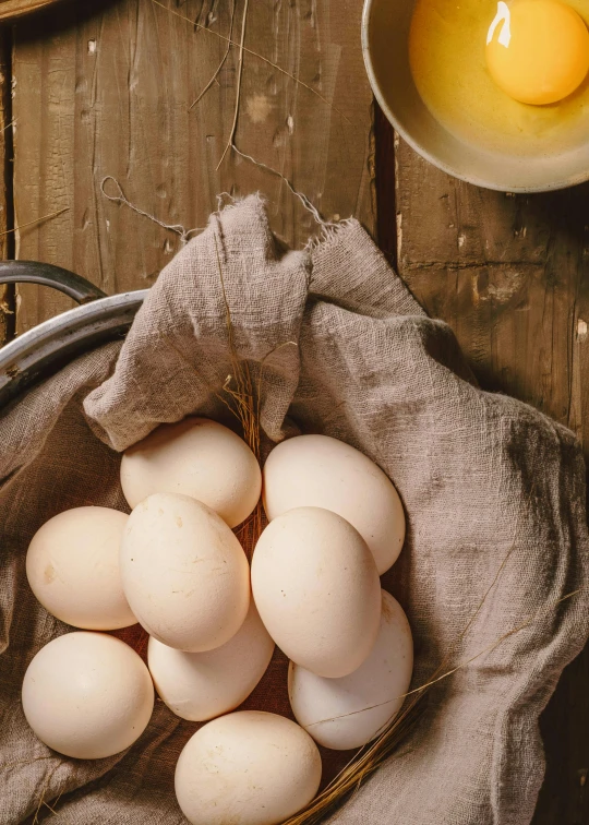 several eggs in a basket, next to a glass of milk