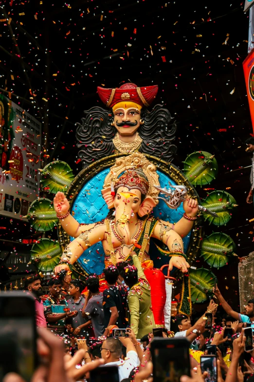 a giant statue with people around it and confetti flying all over