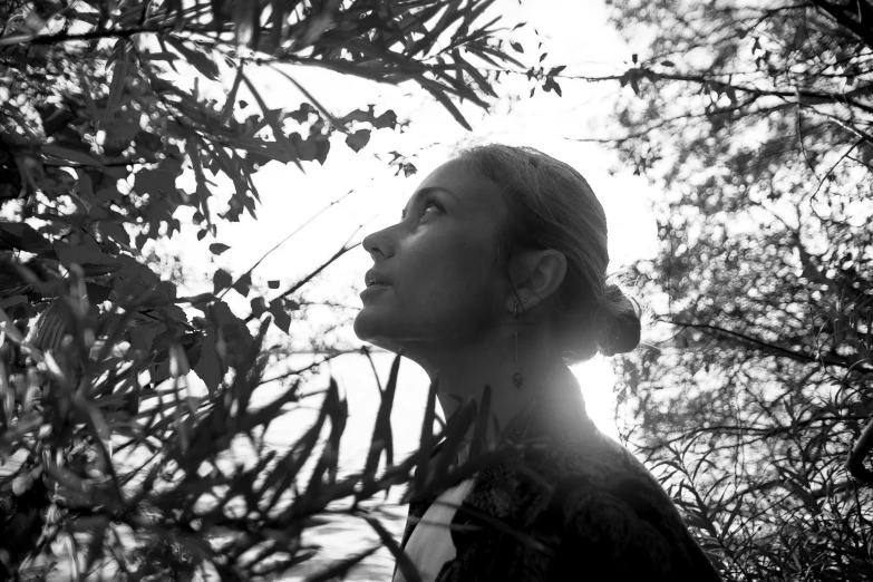 a woman standing in a field and looking up