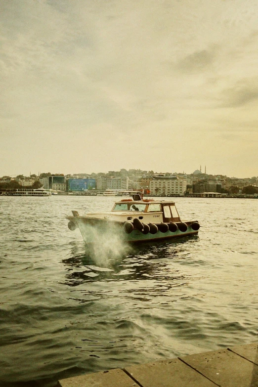 a small boat with several seats is at the dock in front of a city