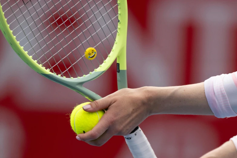 a tennis player wearing white is holding a green and yellow tennis racket