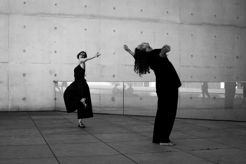 two women dressed in old black clothing, dancing