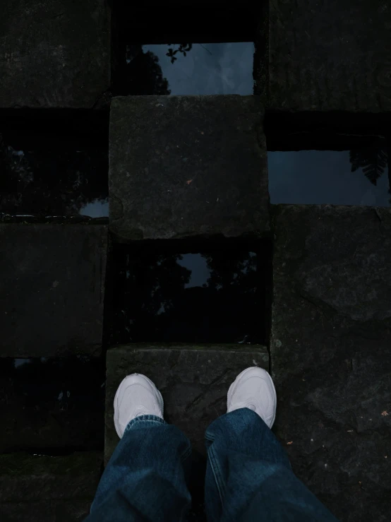 someone standing on cobblestone looking down at their shoes