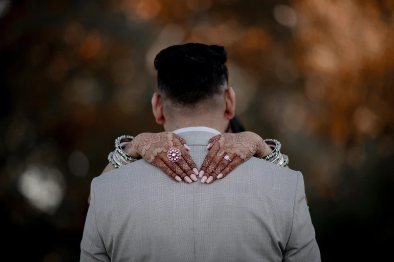 a closeup s of a bride and groom holding hands on the back of their wedding day