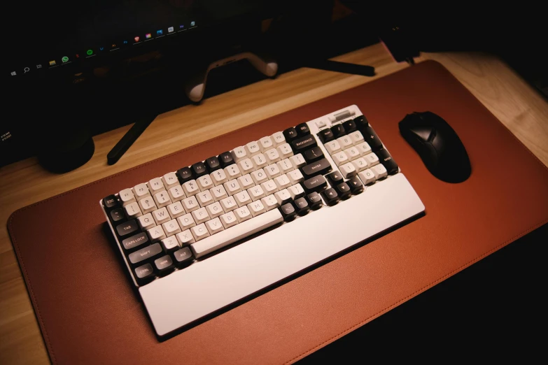 a keyboard with a mouse on a desk