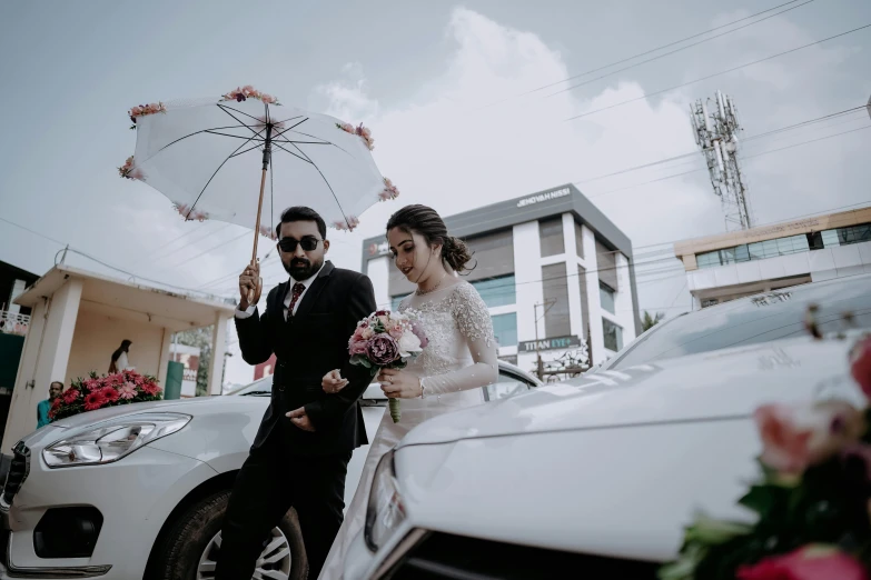 bride and groom walking next to wedding car