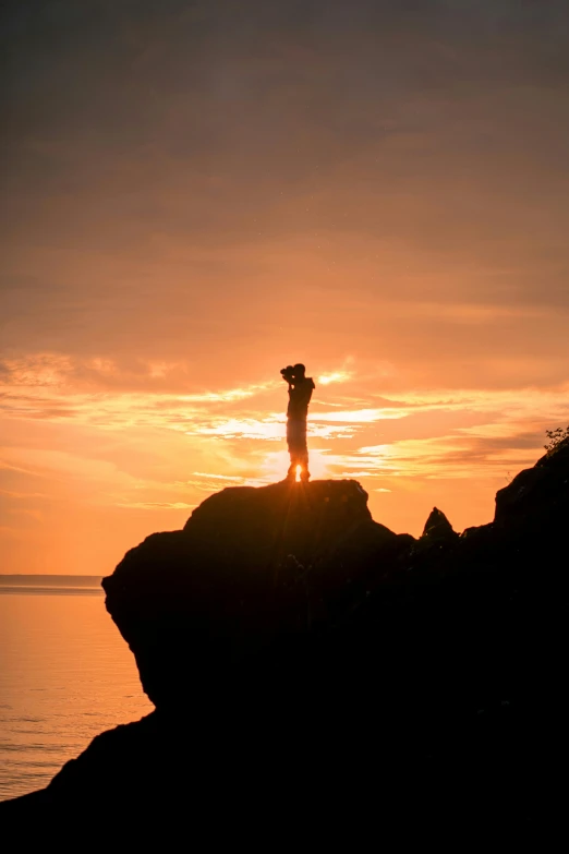 a person standing on a rock with their arms in the air