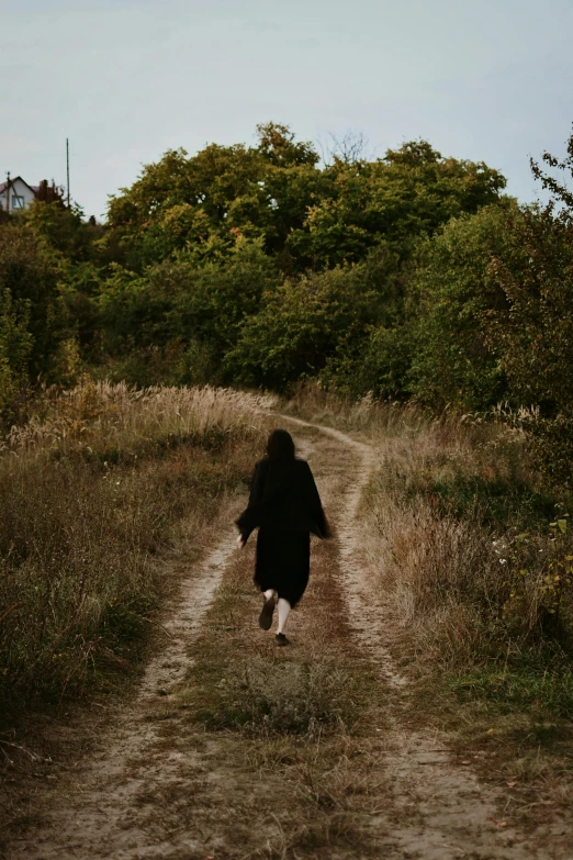 a person that is walking down a dirt road