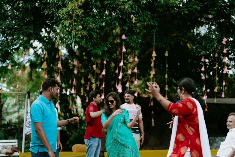 a group of people standing around with a woman in a sari