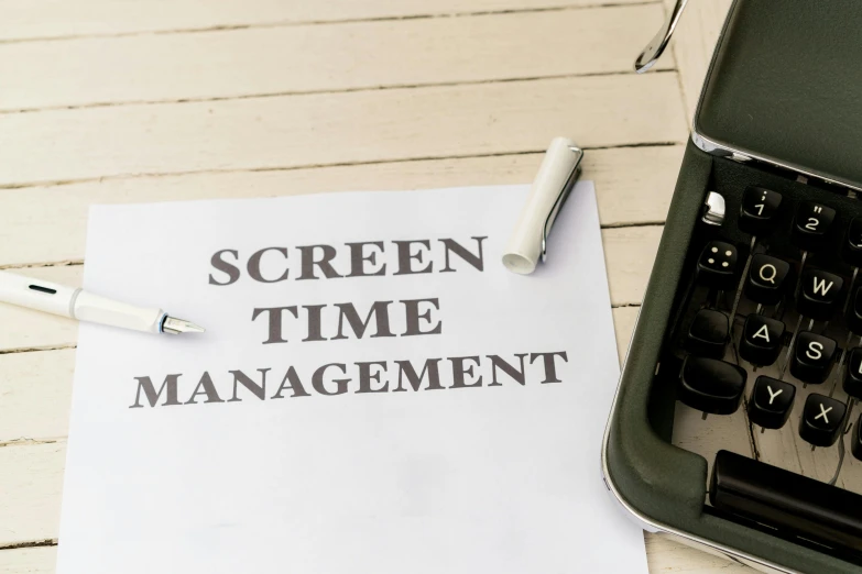 a sheet of paper with the words screen time management next to a keyboard