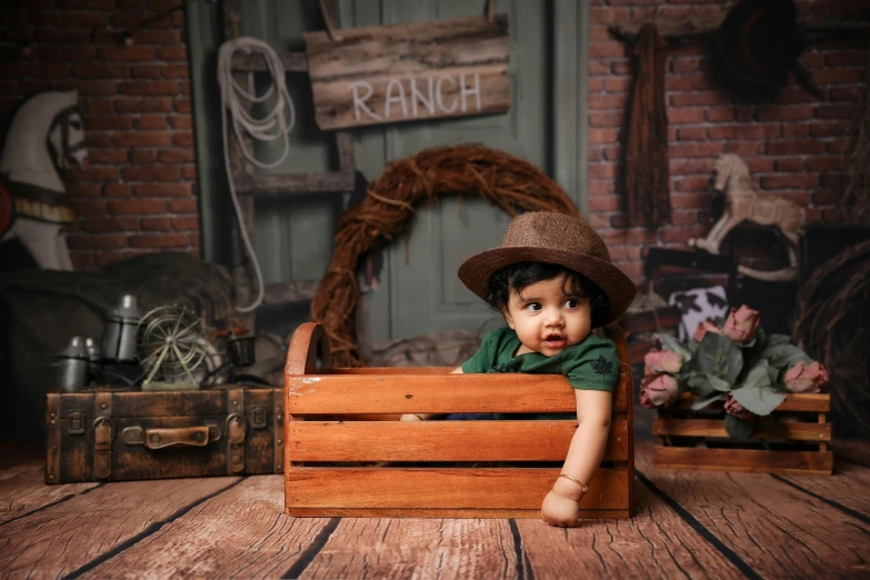 a small child in a hat is in a wooden box