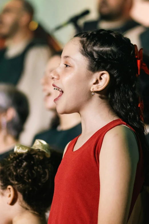  wearing red performing at concert with musical instrument in background