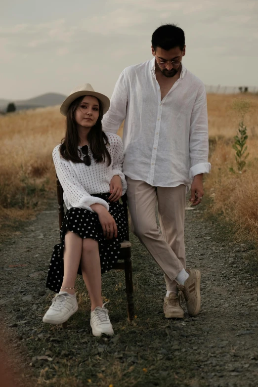 a man standing next to a girl on a chair