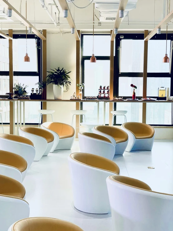 a room filled with lots of white chairs and windows