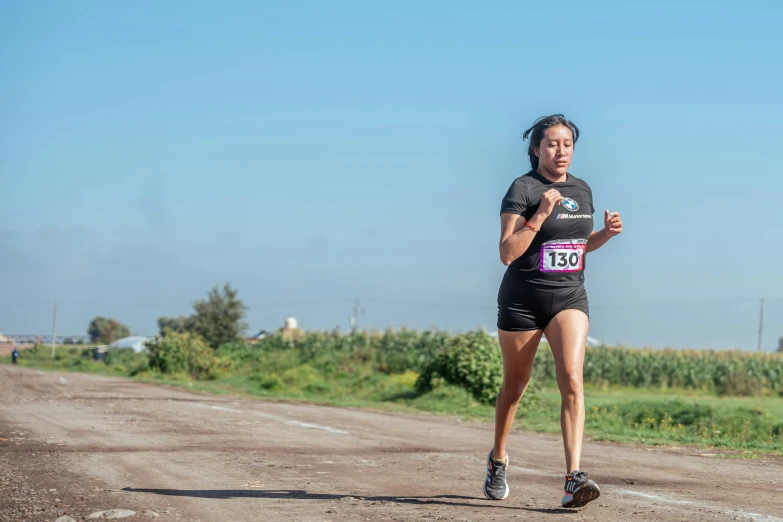 a woman is running on a dirt road