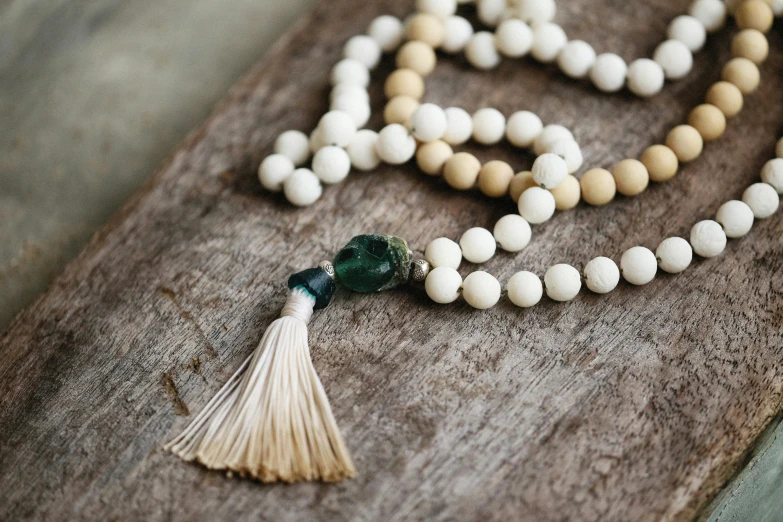 white beads and tassels on a wooden surface