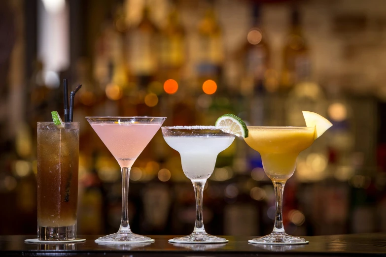 three different types of cocktails on a bar