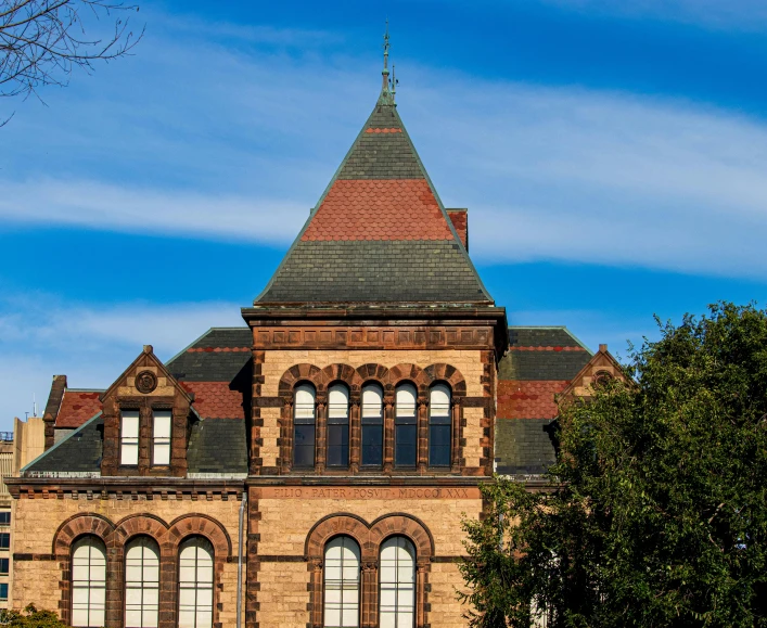 a tall brick building with arched windows near trees