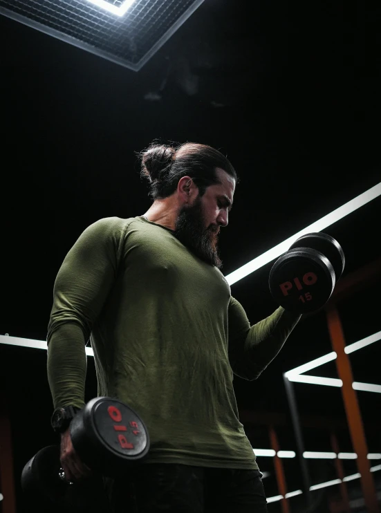 a man with a goatee and long hair holding up two boxing gloves