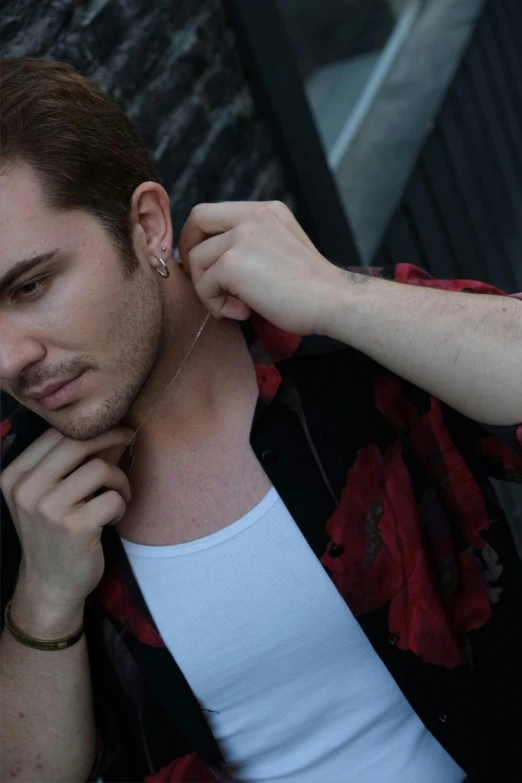 a young man with tattoos is wearing ear studs