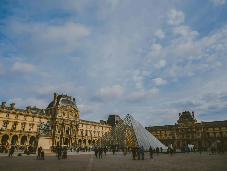 a courtyard with large building with a pyramid on the ground