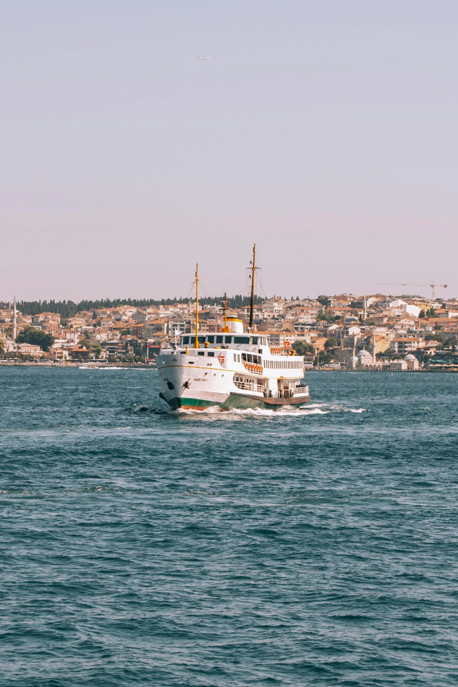 a ferry boat with a city skyline in the background