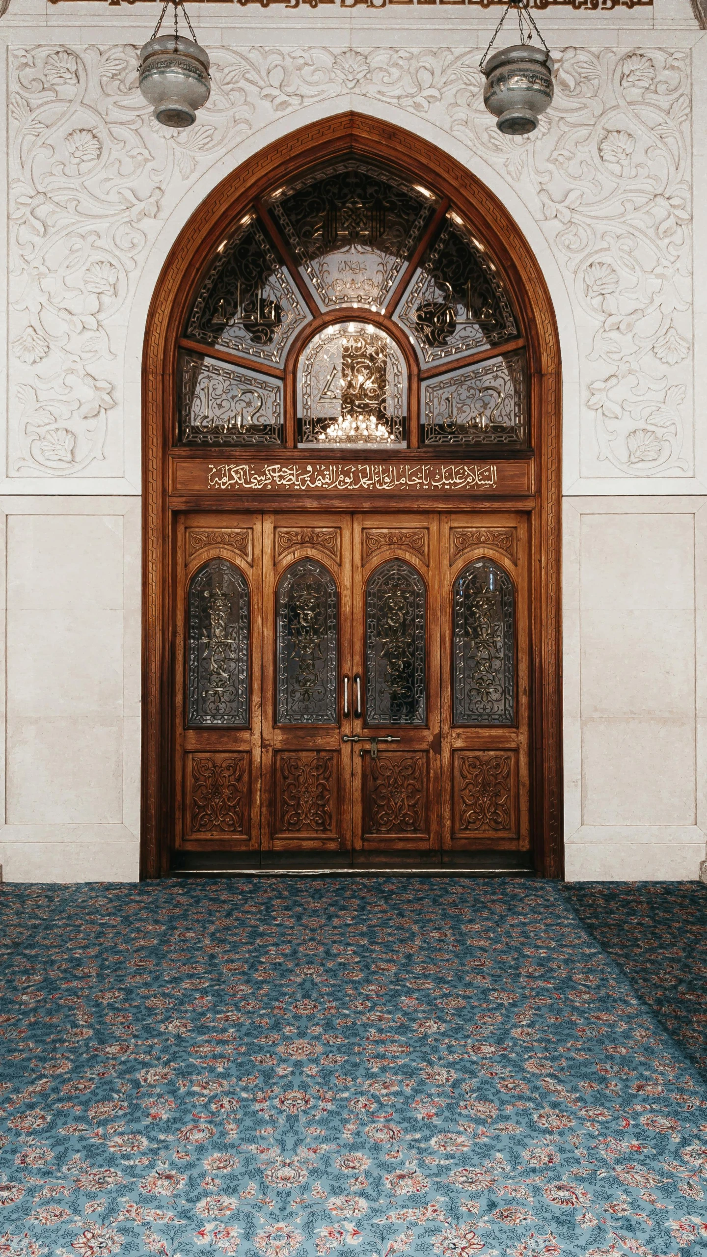 a set of wooden door that has windows above them