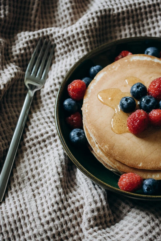 pancakes with er and blueberries on top with syrup