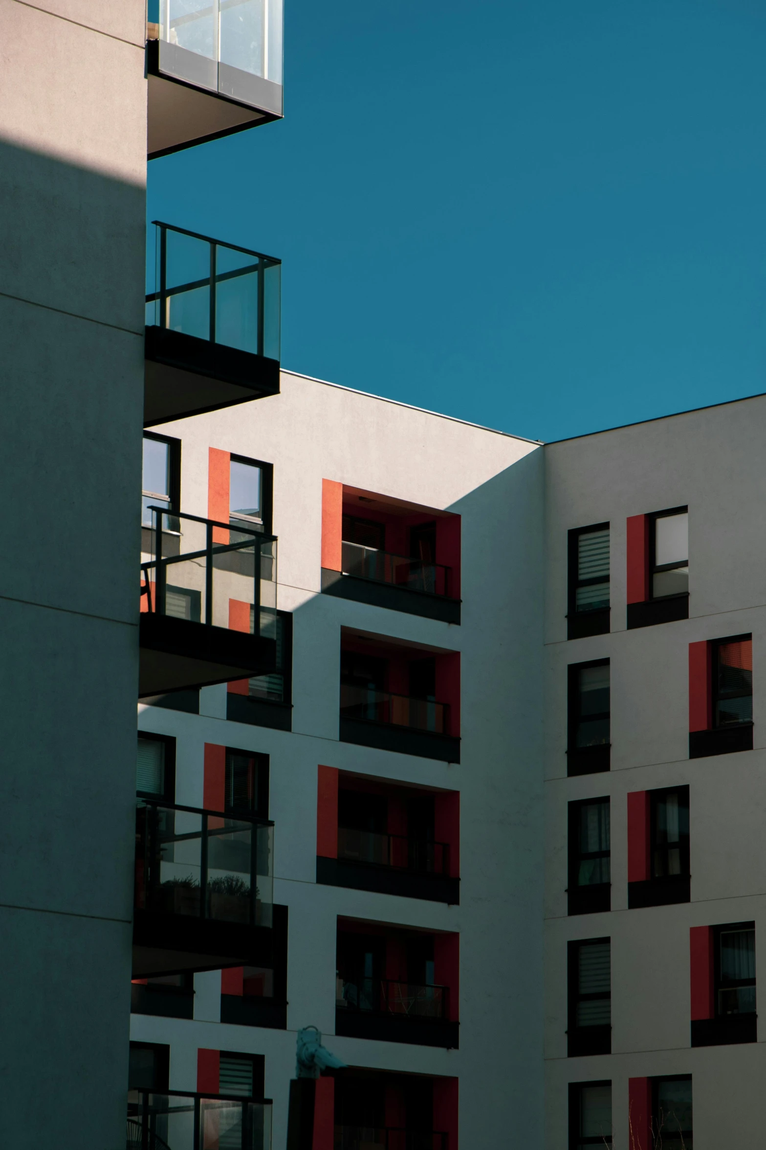 a city building has multiple red windows and balconies