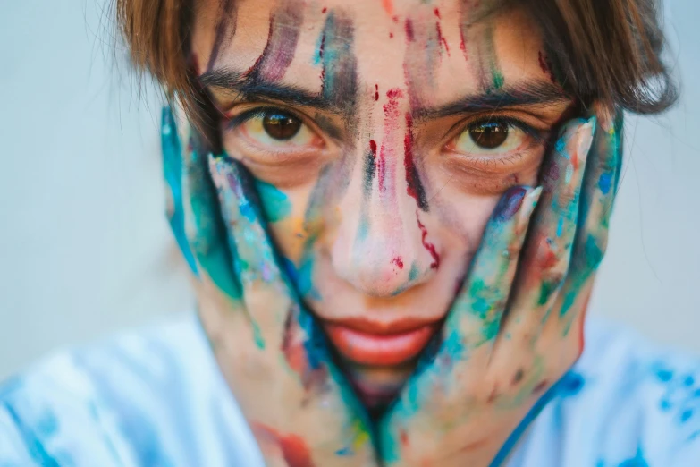 a man covered with paint covering his face and hands