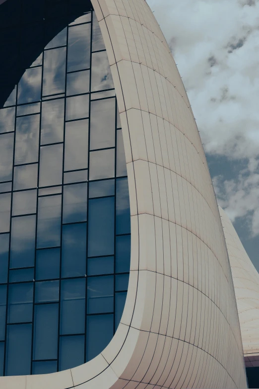 an unusual shaped building with a sky in the background