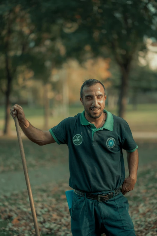 a man holding a wooden stick stands in the field