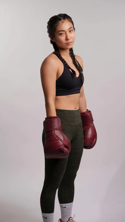 a young woman wearing boxing gloves posing for a po